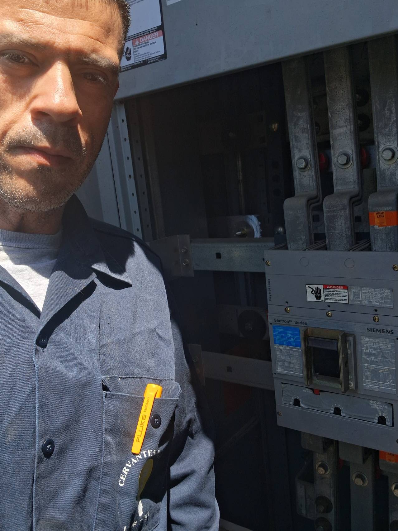 Cervantes Electric technician beside a Siemens 600A commercial panel
